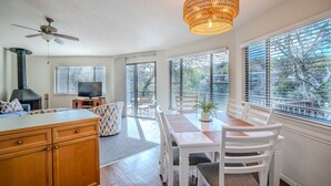 A modern kitchen with a stove, dining area with a table and chairs, and a ceiling fan. - Lakefront Retreat with Pool & Hot Tub [#1 Ocotillo] (Lakeway)