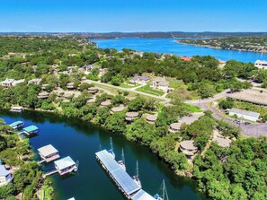 Un port de plaisance avec des bateaux amarrés et une zone résidentielle comprenant des maisons et de la verdure.