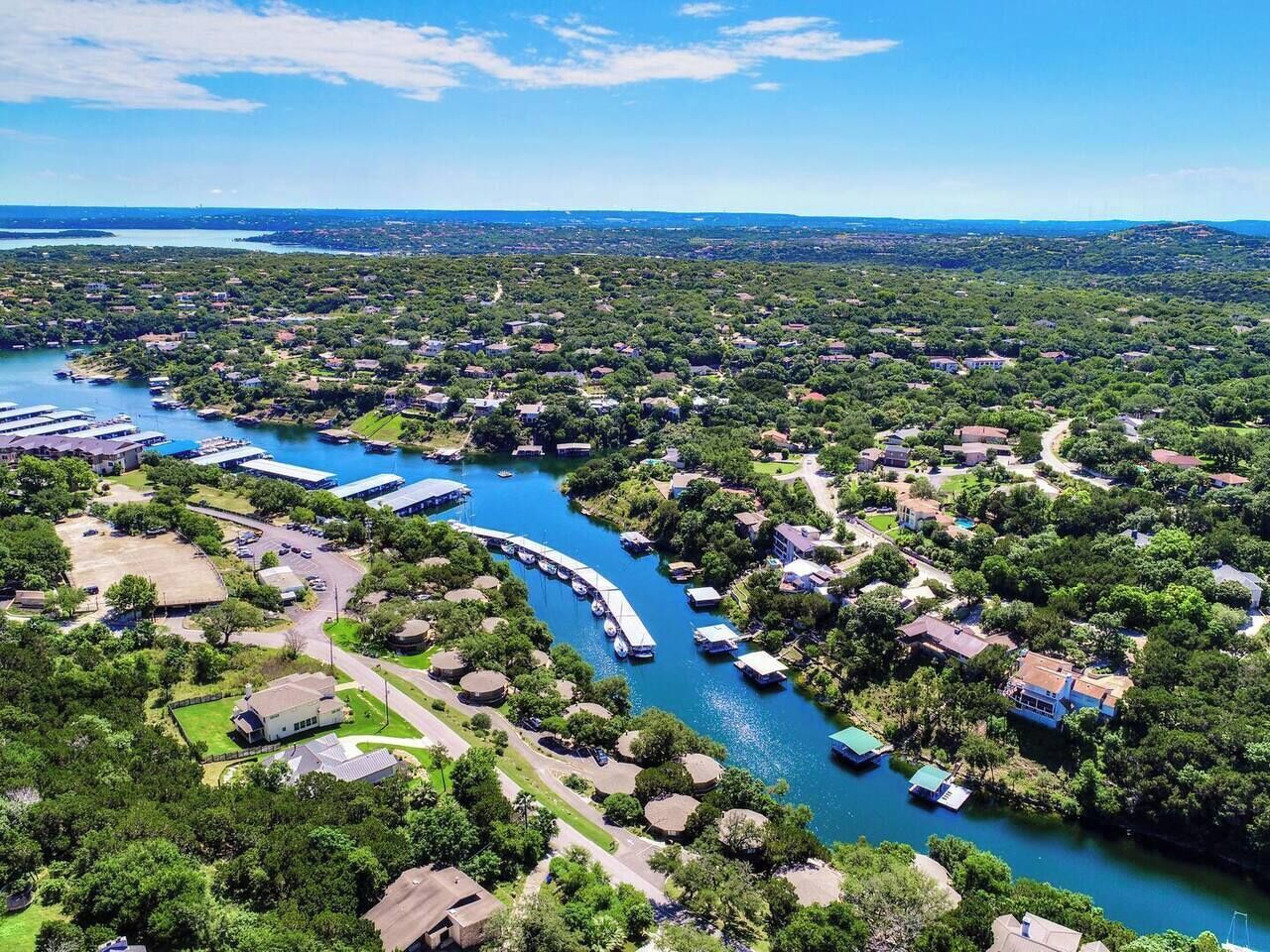 An aerial view of a residential area with a river, houses, and docks.