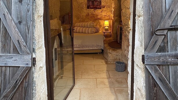 A rustic stone-walled room with a bed, a lamp, and a framed picture on the wall. - AMMARE BY THE SEA         (Marina di Novaglie)