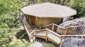 A small, single-story building with a sloped roof, a wooden staircase, and a door marked with the number 6. - Gorgeous Waterside Holiday Rental in Lakeway with pool/jacuzzi [#6 Primrose] (Lakeway)
