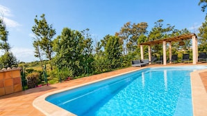 A swimming pool with a pergola and lounge chairs. - Can Pou - private pool - wifi - AACC (S'Aranjassa)