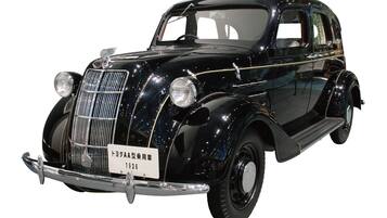 Ein klassischer, schwarzer Wagen mit Chromgrill und Scheinwerfern, einem Nummernschild und zeitlosem Design.