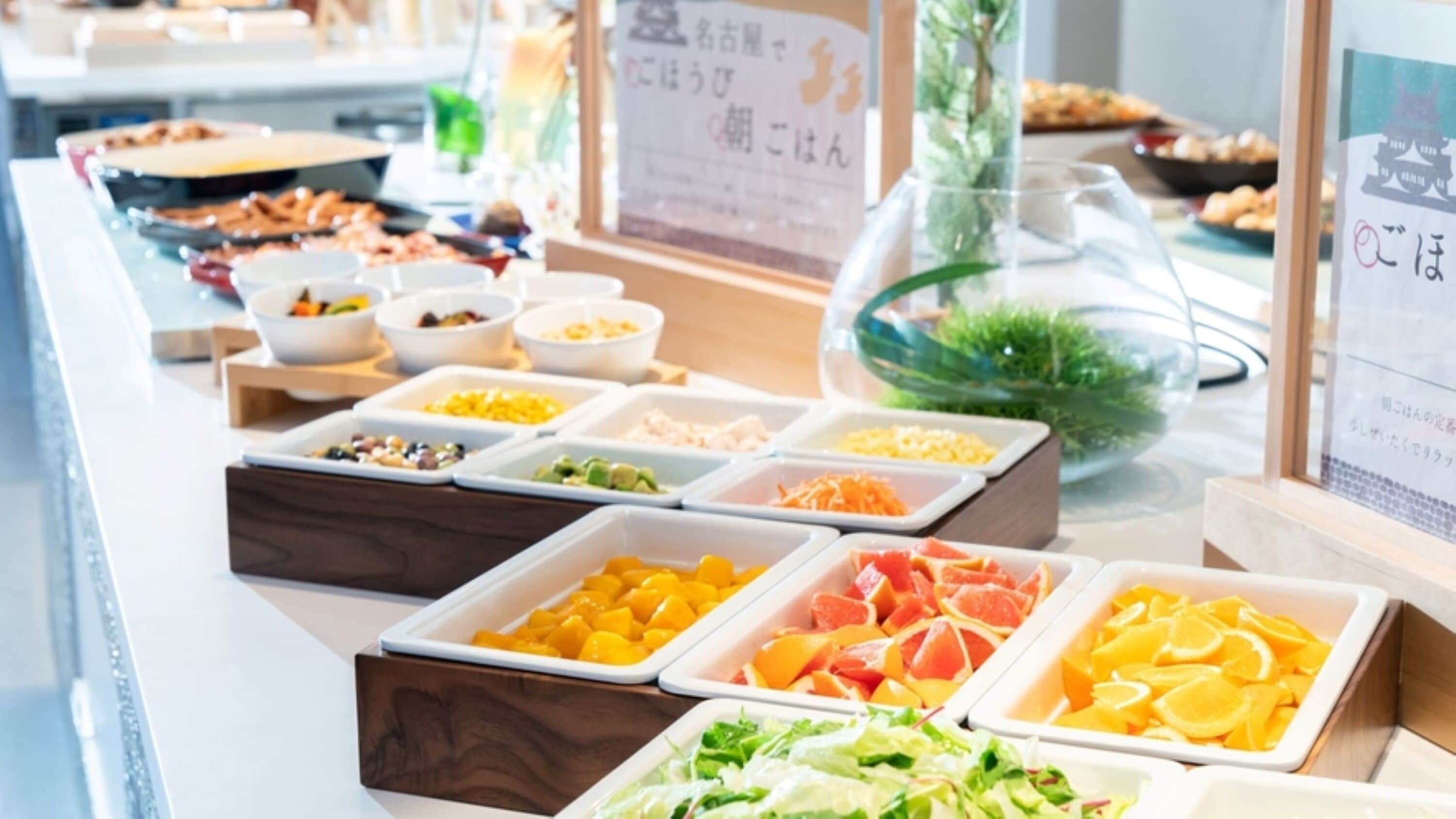 A buffet with various food items including fruits, vegetables, and meats.