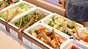 A buffet with various vegetable dishes, each with a wooden spoon.