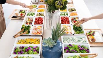 A buffet table with various food options and a decorative vase.