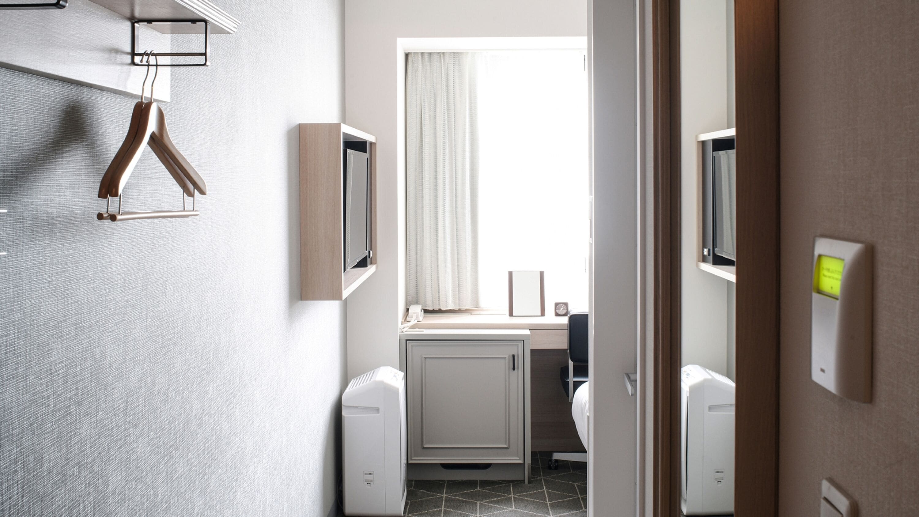 A modern bathroom with a shower, toilet, and sink. There is a towel rack and a mirror on the wall.