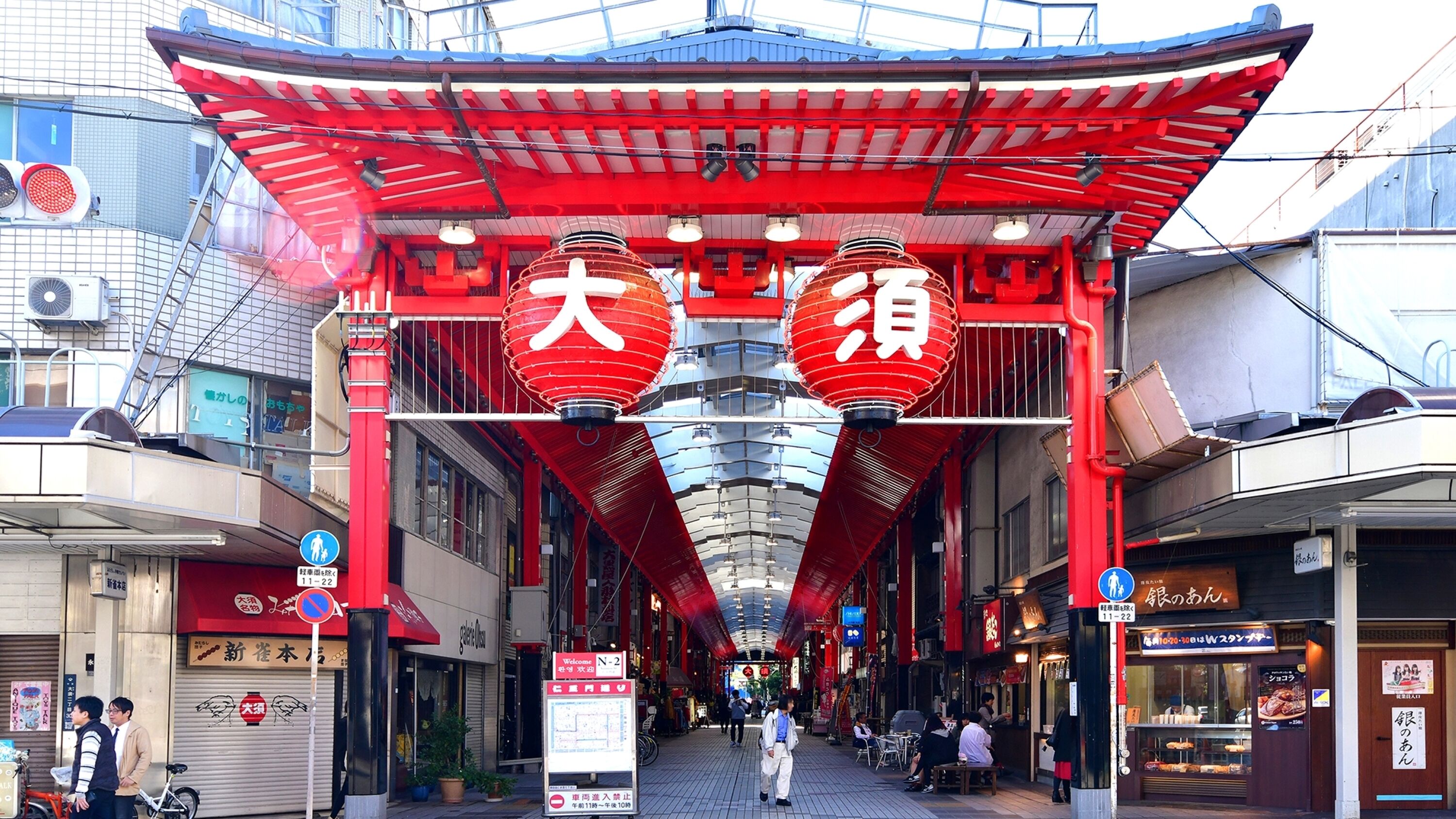 A traditional Japanese street with red lanterns and a covered walkway.