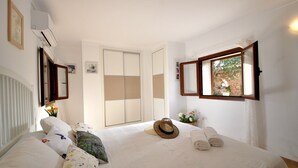 Una camera da letto con un letto, una finestra vista, una porta e un condizionatore.