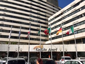 A hotel with multiple floors and balconies, featuring flags of Portugal, Germany, and Italy. - Ondina Apart Hotel Residence (Salvador)