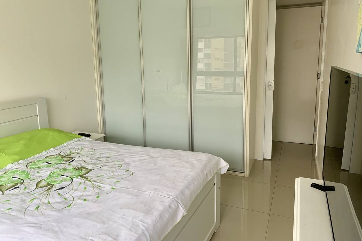Une chambre à coucher comprenant un lit, une armoire et une porte donnant sur une autre pièce.