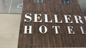 Et hotelskilt med navnet "SELLER HOTEL" på en moderne bygning.