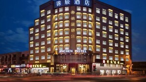 Un hotel de varios pisos con letreros iluminados y una entrada destacada.