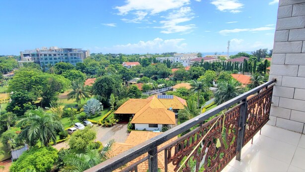 A residential area with a mix of modern and traditional buildings, lush greenery, and a clear sky. - Luxury Residence with Ocean View in Masaki (Dar es Salaam)