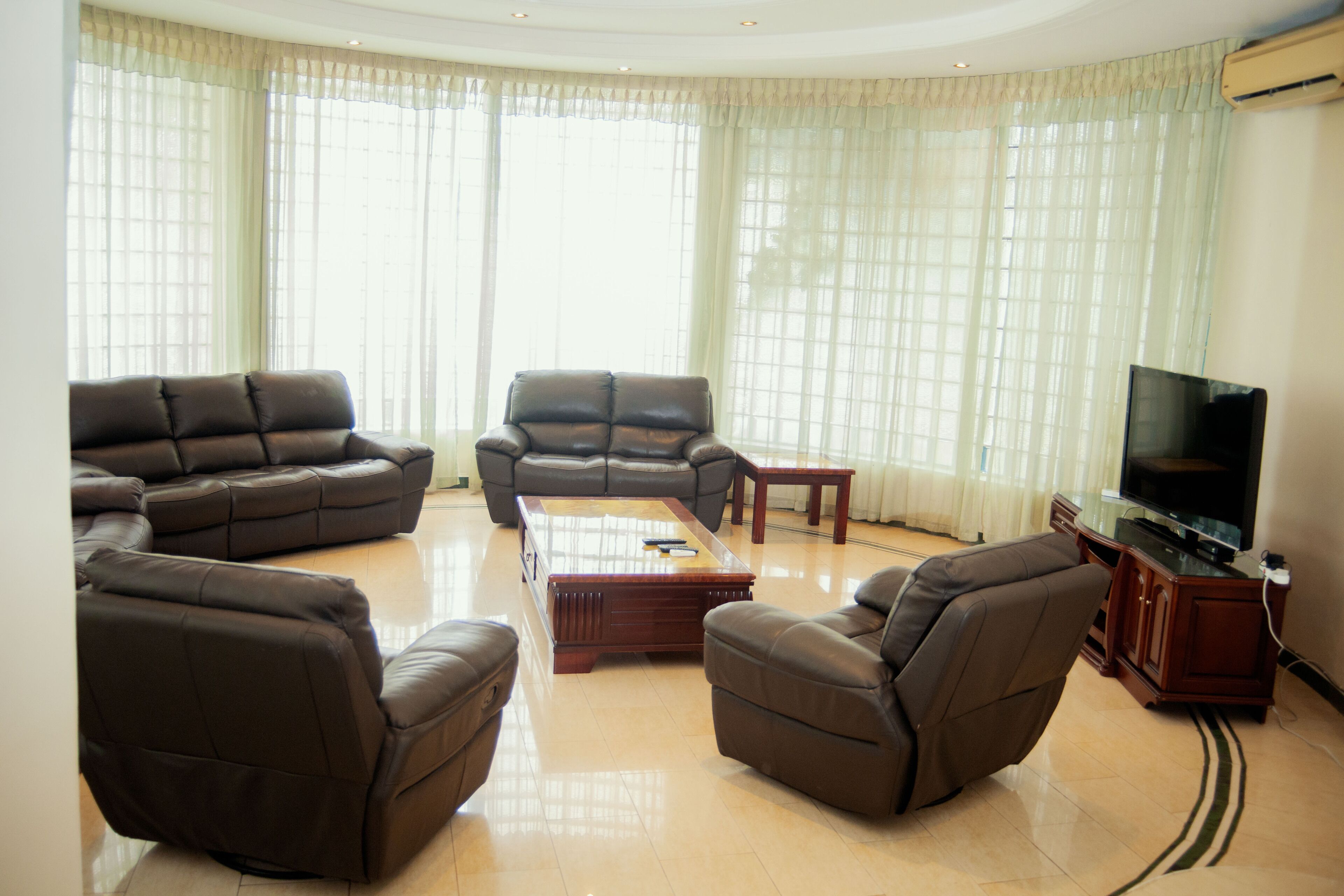 A living room with a sectional sofa, a recliner, a coffee table, and a television on a stand.