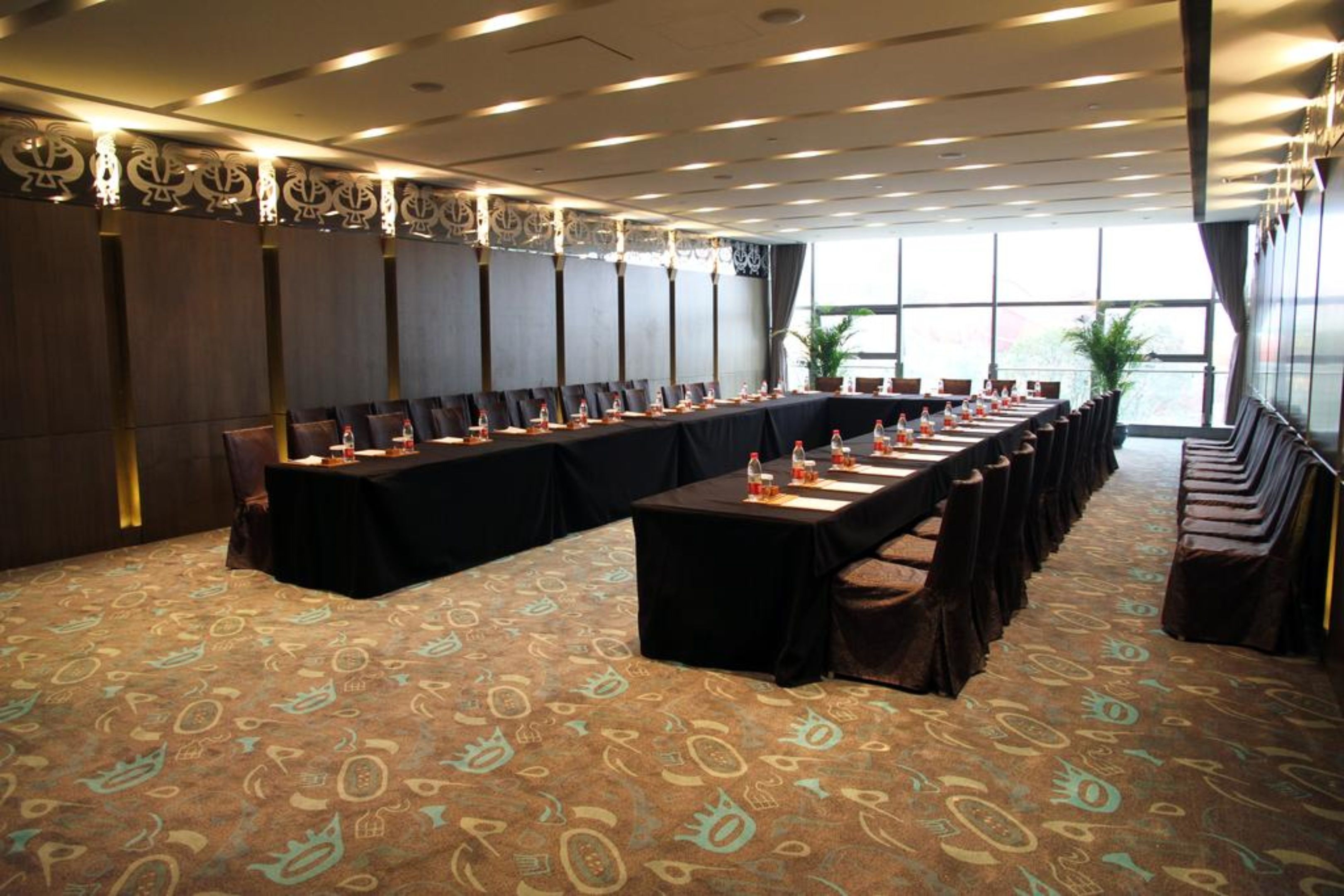 Una sala conferenze con un lungo tavolo, sedie e una moquette fantasia.