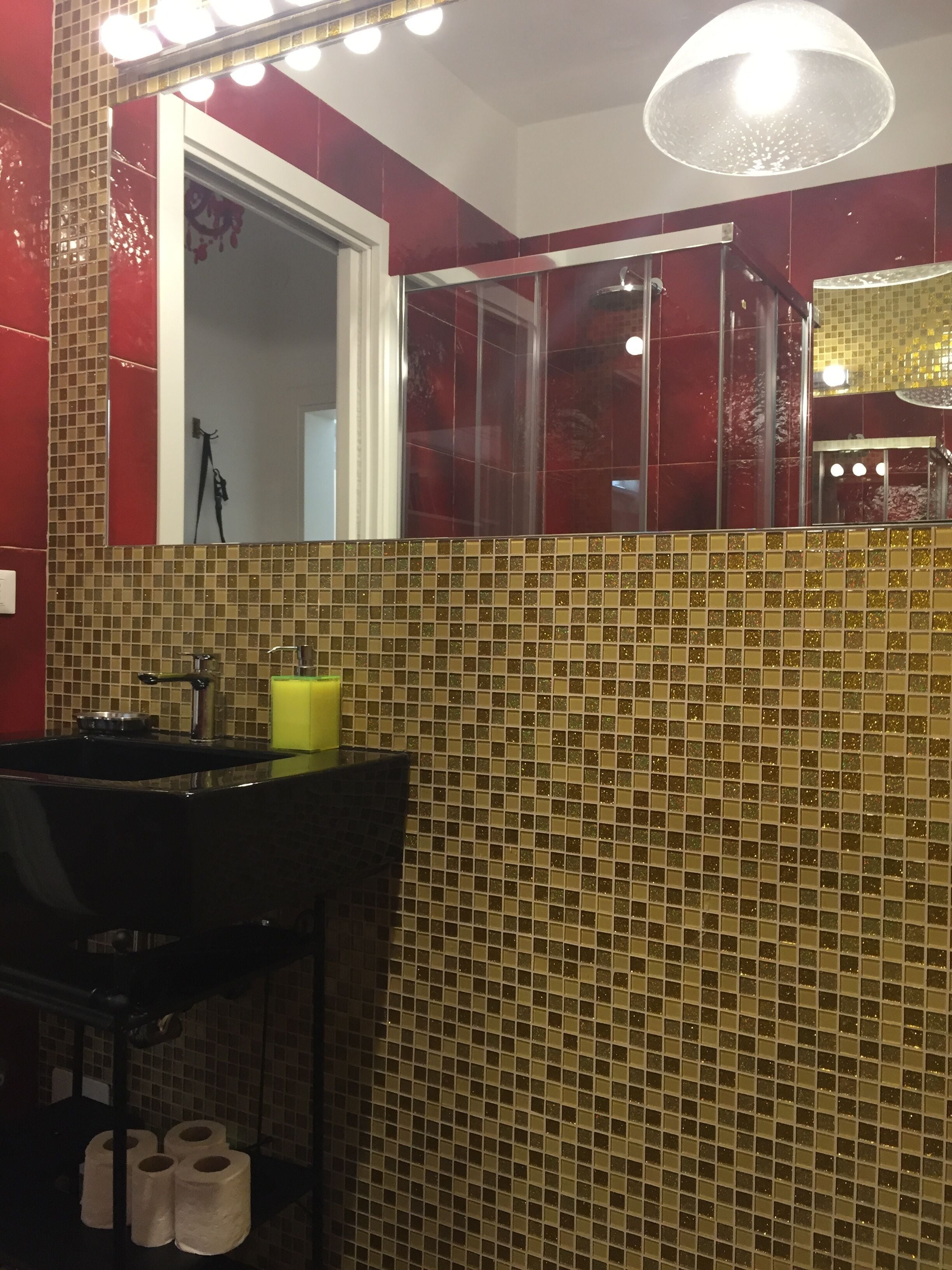 A bathroom with a sink, mirror, and tiled walls.