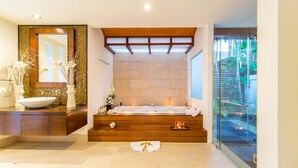 A modern bathroom with a large bathtub, a wooden vanity, a large mirror, and a glass shower enclosure. - Baan Ban Buri (Koh Samui)