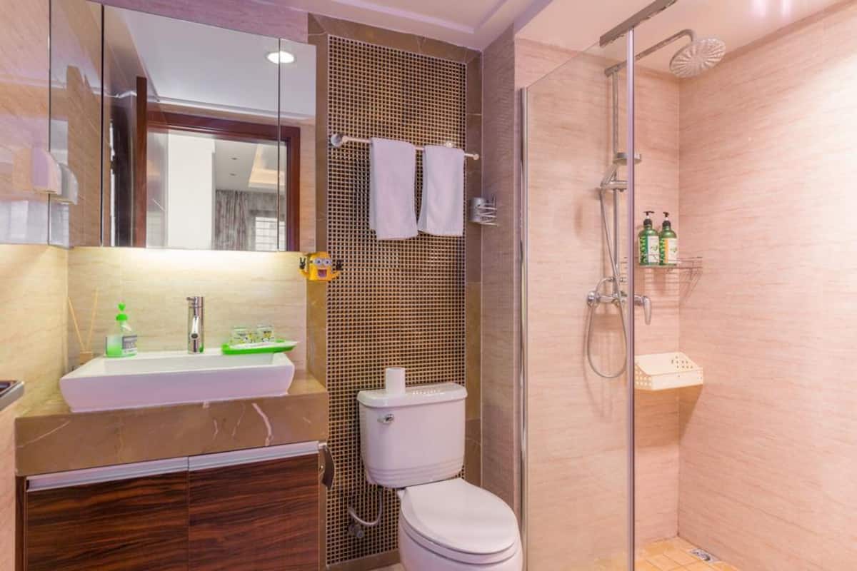 Un baño con lavamanos, inodoro y ducha.