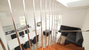 Un intérieur moderne comprenant une cuisine, un coin repas et un salon.