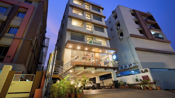 A multi-story hotel with a prominent entrance, a staircase, and a balcony with potted plants. - Treebo Premium PL Grand, Visakhapatnam (Visakhapatnam)