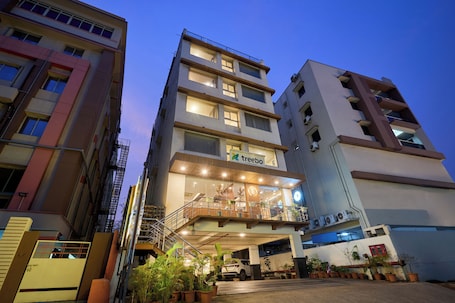 A multi-story hotel with a prominent entrance, a staircase, and a balcony with potted plants.. Treebo PL Grand, Vishakapatnam