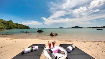 Na praia, areia branca, espreguiçadeiras