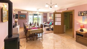 Zona pranzo con tavolo imbandito per quattro persone, un divano e un armadio in legno.