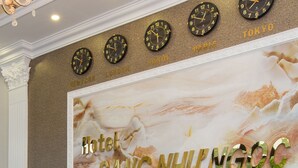 Un comptoir d’accueil d’hôtel avec des horloges indiquant l’heure à New York, Londres, Paris et Tokyo.