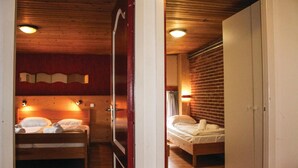 A hotel room with two beds, wooden flooring, and a brick wall. - Awesome apartment in Simpelveld with outdoor swimming pool (Simpelveld)