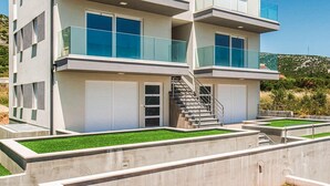 A modern multi-story building with balconies, a staircase, and a well-maintained lawn. - Nice apartment in Trogir with WiFi (Trogir)
