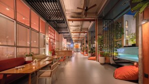 A modern interior with a long hallway, seating areas, and a view of a pool. - Craftsman Bangkok (Bangkok)