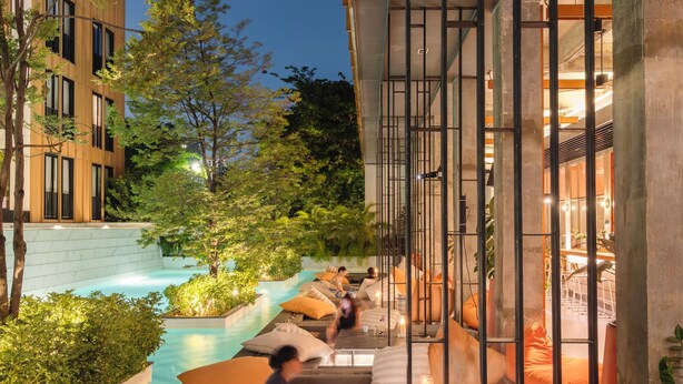 A poolside area with seating, a view of the building, and a clear sky. - Craftsman Bangkok (Bangkok)