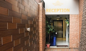 A reception area with a sign reading "RECEPTION" above a doorway. - Hotel Indralok Inn (Mawal)