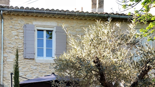 A stone house with a small patio, a door, and a window with shutters. - In the heart of downtown St Rémy de Provence, the Mas D'Oscar! (Saint-Rémy-de-Provence)