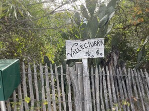 Surrounded by lush foliage, the rustic entrance to Valle Cuirra welcomes you.