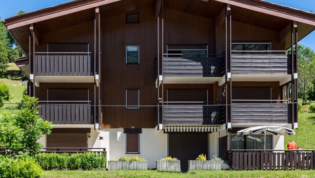 A multi-story building with balconies, a garage, and a landscaped garden. - La Clusaz - 6 pers - 2 Bdr - Near slopes - Garage (La Clusaz)