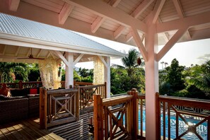 Un espacio al aire libre cubierto con piscina, terraza de madera y asientos tipo sala de estar.
