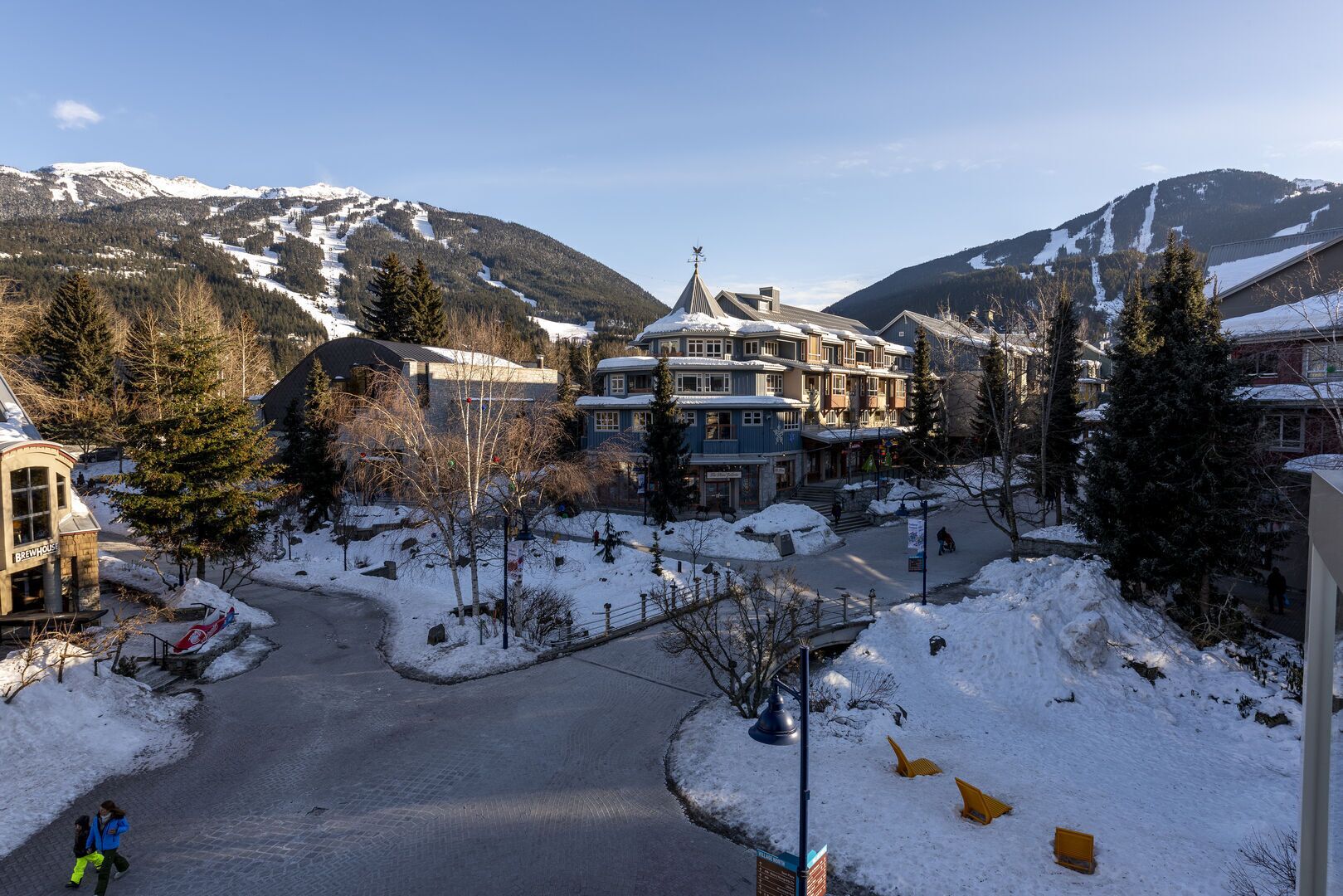 A hotel with a central building surrounded by snow-covered landscape and mountains.