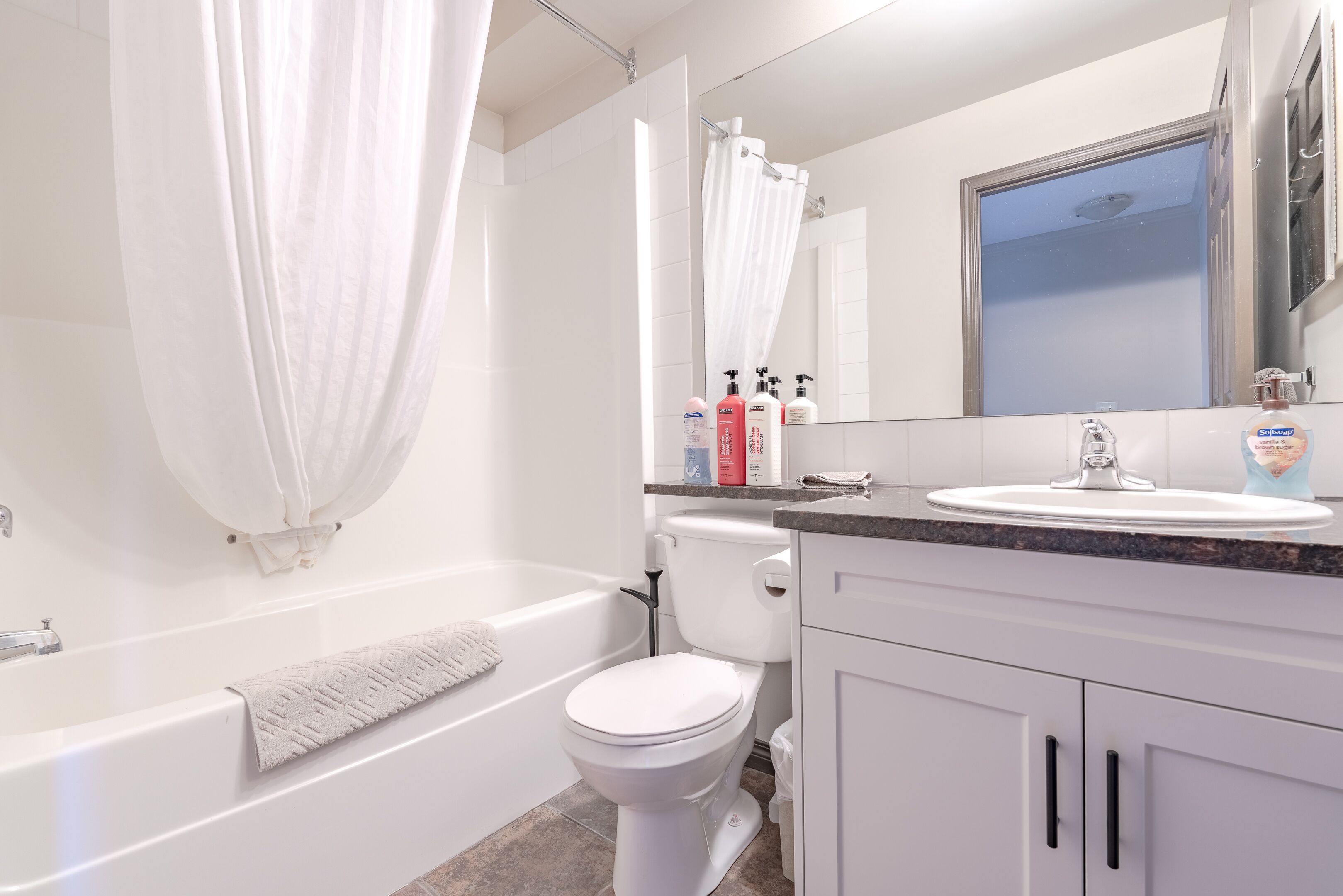 A modern bathroom with a bathtub, toilet, and sink.