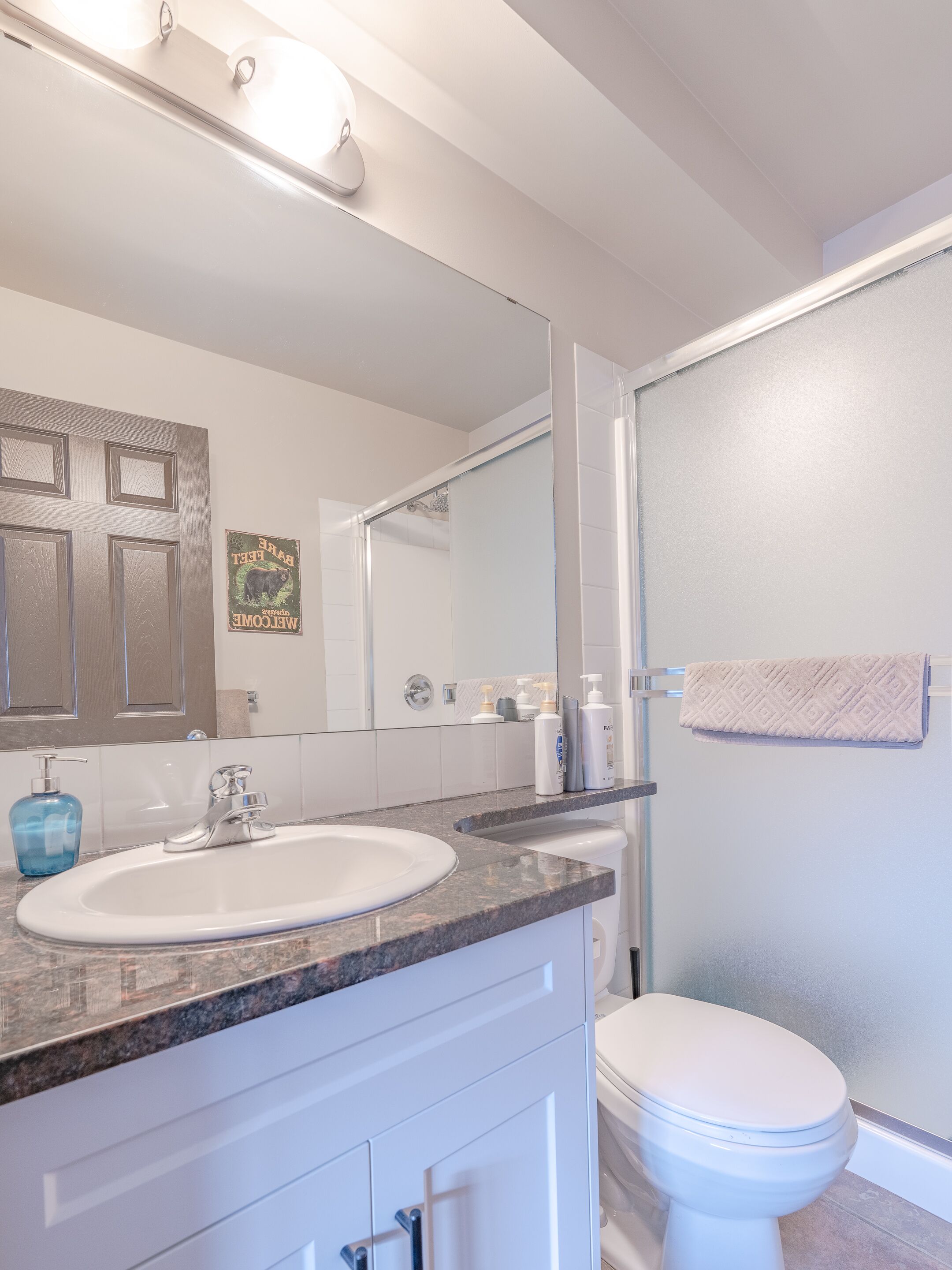 Un baño moderno con un lavamanos blanco, un espejo y un inodoro.