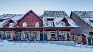 Useita kerroksia sisältävä kivirakennus, jossa on punainen katto, useita ikkunoita ja lumipeitteinen maa.