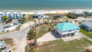 Vista aérea de una propiedad costera con piscina, acceso a la playa y varias construcciones.