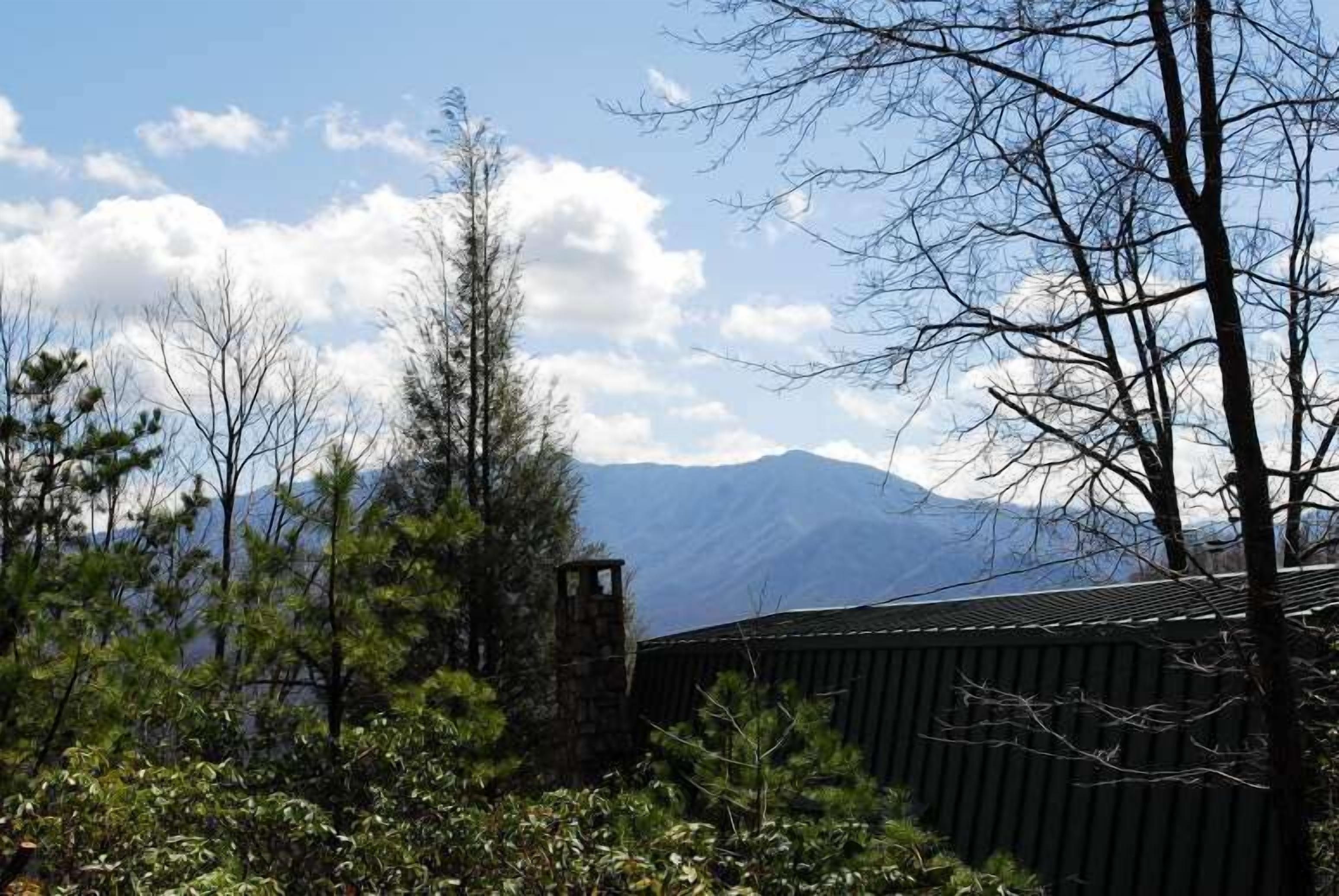 A mountainous landscape with a wooden structure and trees.