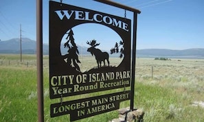 Un panneau d’accueil à l’entrée de la ville d’Island Park, qui souligne son statut de zone de loisirs accessible toute l’année et le fait que sa rue principale est la plus longue des États-Unis.