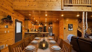 A wooden cabin interior with a dining area, kitchen, and living room. - 22 MI to YNP | Firepit & Patio | Spacious Lodge (Island Park)