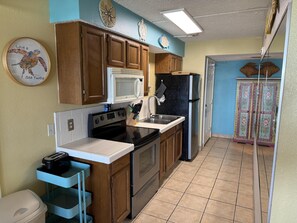 A kitchen with wooden cabinets, a microwave, a refrigerator, and a toaster.