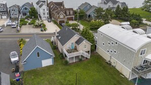 Un quartier résidentiel avec des maisons, une allée et une vue sur la mer.