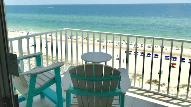 A balcony with a view of a beach, a table, and two chairs. - Beachfront Penthouse Located On The 9th Floor with Two Balconies & Low Host Fee (Gulf Shores)