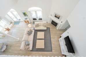 Amplia sala de estar con un conjunto de sofás, una mesa de centro, una chimenea y un televisor.
